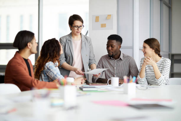 Multi-Ethnic Group of Businesspeople Portrait of successful female manager leading multi-ethnic team in meeting, copy space Trainee stock pictures, royalty-free photos & images