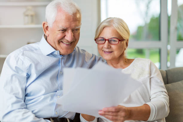 istock Older couple reading papers together on sofa 1139897988