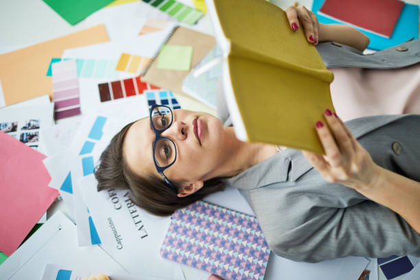 istock Businesswoman Reading Book on Floor 1139898027