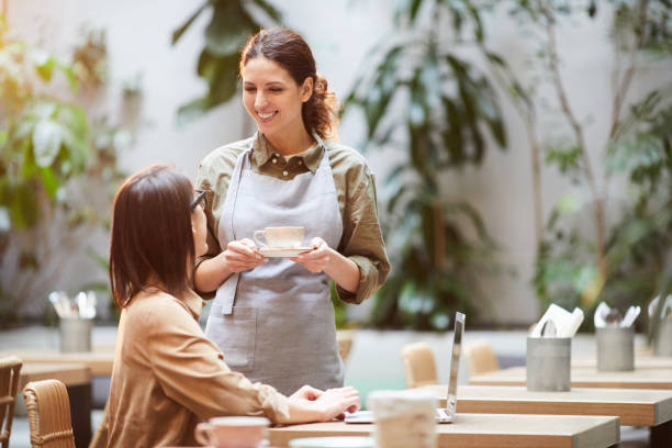 istock Attractive waitress serving coffee to guest 1139899138