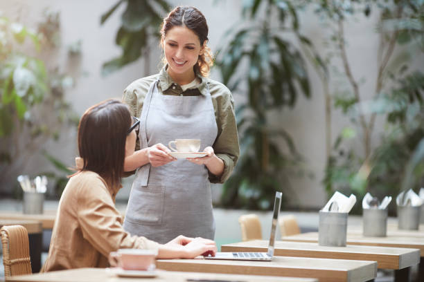 istock Pretty waitress giving coffee cup to client 1139899148
