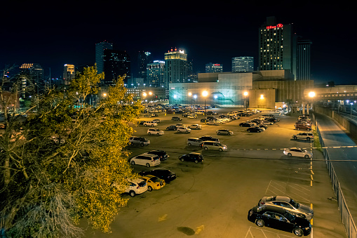 New Orleans, USA - Dec 4, 2017: Night view of the car park at Julia Street Station, with city skyline in the background. View from the station bridge.