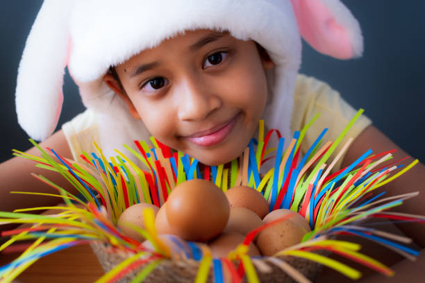 Happy easter! Close up cute girl wearing rabbit hat with chicken eggs in a basket, Easter holiday concept.