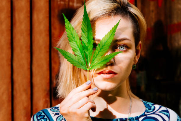 istock A girl with a cannabis leaf near her face 1139903730
