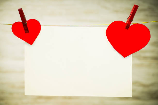 istock A white card and two red hearts hanging on a string, fastened with red buckles 1139903747