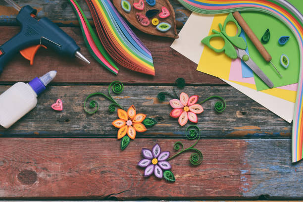 istock Quilling technique. Paper strips, flowers, scissors, elements. Handmade crafts on holiday theme: Birthday, Mother's Day, March 8, Wedding. Making decoration or greeting card. Children's DIY concept. 1139905477