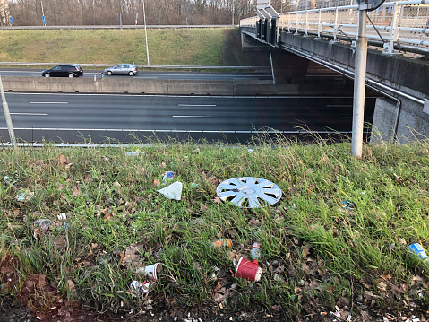 Waste tossed out of cars, lying in the shoulders of the exit of the freeway ring A10 (around Amsterdam)