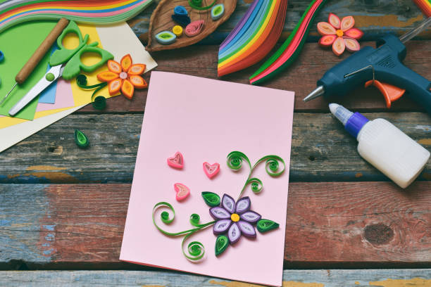 istock Quilling technique. Paper strips, flowers, scissors, elements. Handmade crafts on holiday theme: Birthday, Mother's Day, March 8, Wedding. Making decoration or greeting card. Children's DIY concept. 1139906535