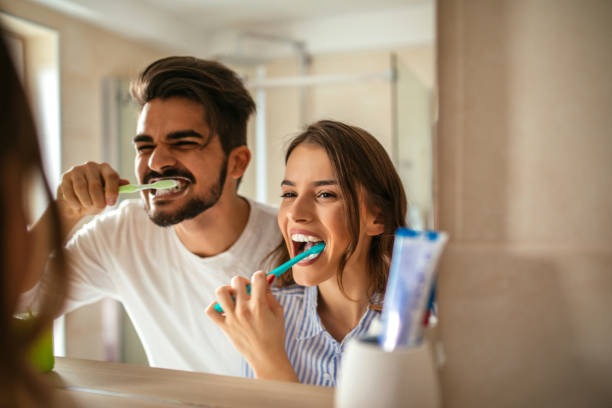 Brushing my teeth Couple doing a morning hyginene together. toothbrush stock pictures, royalty-free photos & images
