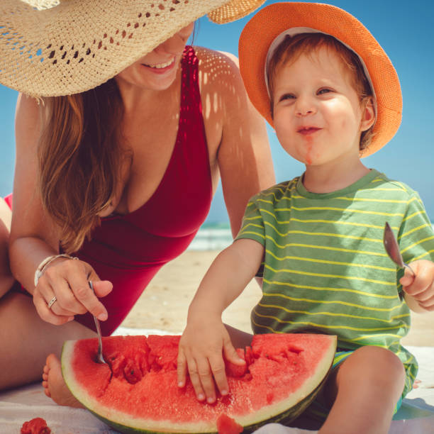 istock Happy family eating watermelon on the beach 1139909867