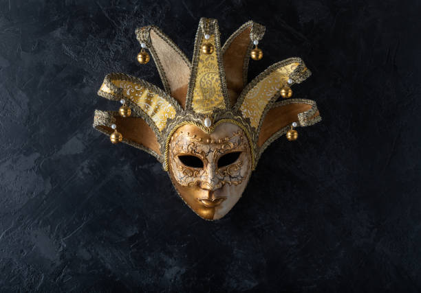 istock Venetian mask on a black background. Gilded mask on a stone black wall background. 1139909978