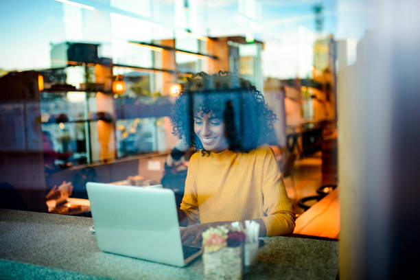 istock Smiling woman using laptop at the bar. 1139911347