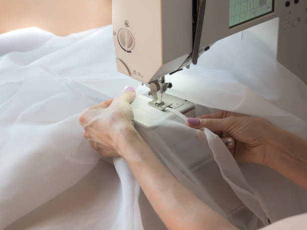 Hand sews a tulle on the sewing machine. Hand sews a tulle on the sewing machine. Close up. Stitch stock pictures, royalty-free photos & images