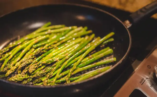 Cooking beautiful and tasty green asparagus in a pan