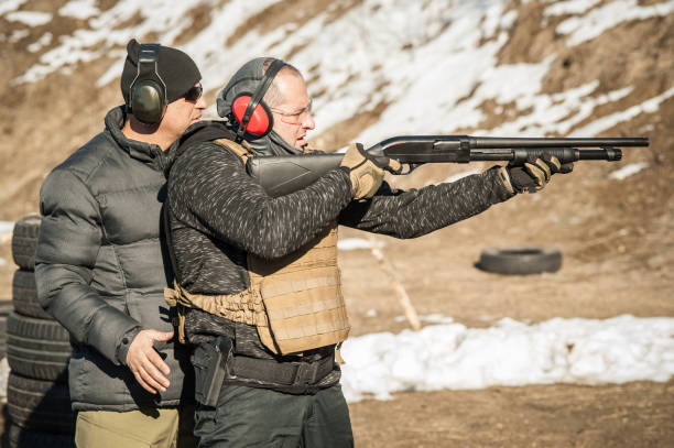 istock Instructor on shooting range teaches student to shoot with shotgun 1139914067