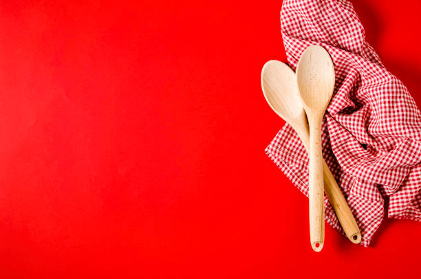 istock Kitchen textiles and wooden spoons on bright red background 1139914129