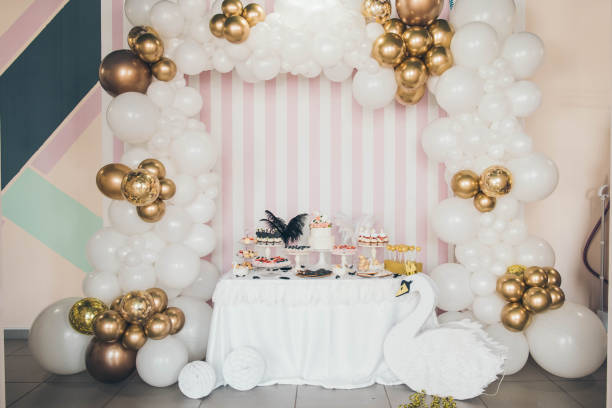 White swan Candy Bar. Design of balloons. Many white and golden balloons decorated wall stock photo