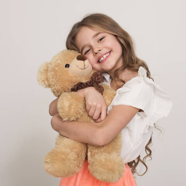 liebenswerte kleine mädchen umarmt teddybär - mädchen teddy stock-fotos und bilder