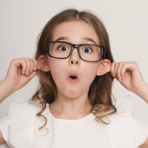 little girl grimacing with tongue out making ears protruding - mockery imagens e fotografias de stock