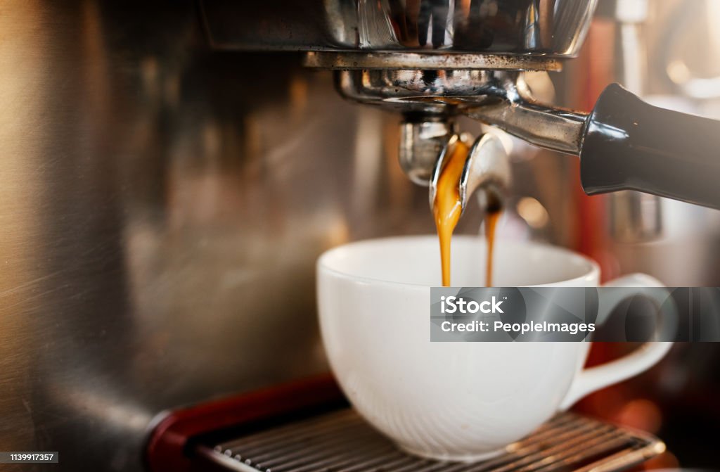 Another one thank you Closeup shot of an espresso maker pouring coffee into a cup inside of a cafe Coffee - Drink Stock Photo