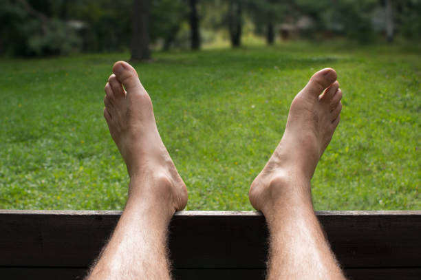 istock Barefoot man relaxing and enjoying a green grass garden 1139917711