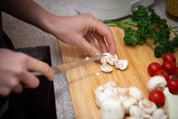 istock Female hand cutting a mushroom 1139917716