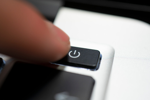 mano humana botón de apagado en el teclado del ordenador photo