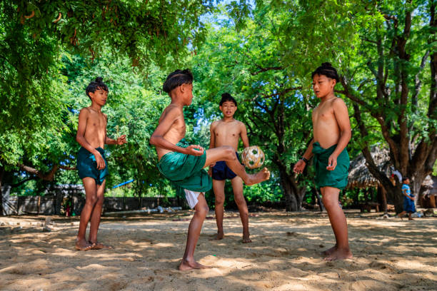 ragazzi birmani che giocano a chinlone nel villaggio vicino a bagan, myanmar - bagan myanmar burmese culture family foto e immagini stock