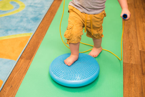 istock little kid massages his feet while standing on the rug 1139923865