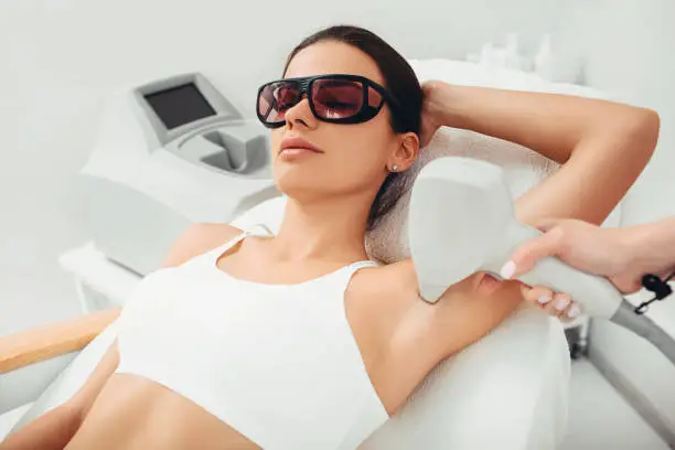 Photo of Woman having hair removal laser epilation on underarm areas. hair reduction