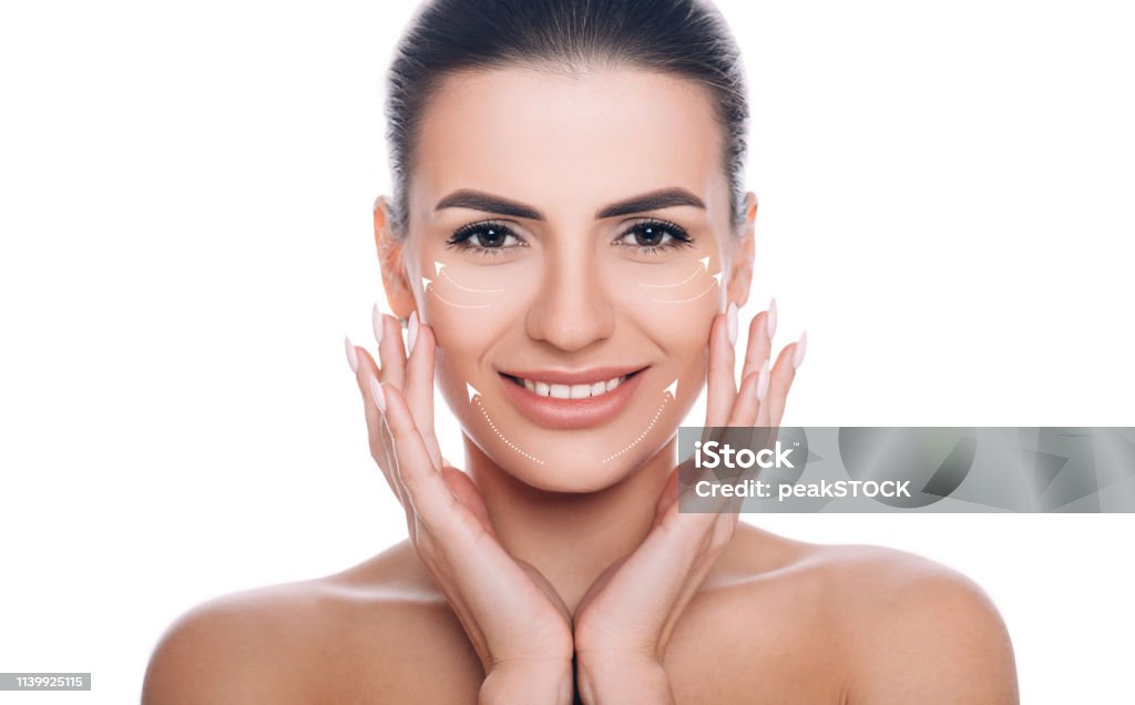 smiling woman with lifting arrows on face. Concept of skin lifting portrait of beautiful woman with perfect skin of the face, with arrows on face, concept of lifting skin. Cosmetology, elastic and young skin of the face. Human Face Stock Photo