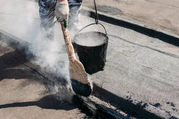 Worker repairs the roof with molten tar from a bucket with a broom. Worker repairs the roof with molten tar from a bucket with a broom. Roof repair tar. black tar stock pictures, royalty-free photos & images