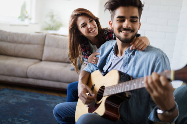 istock Young handsome man playing guitar for his girlfriend 1139929035