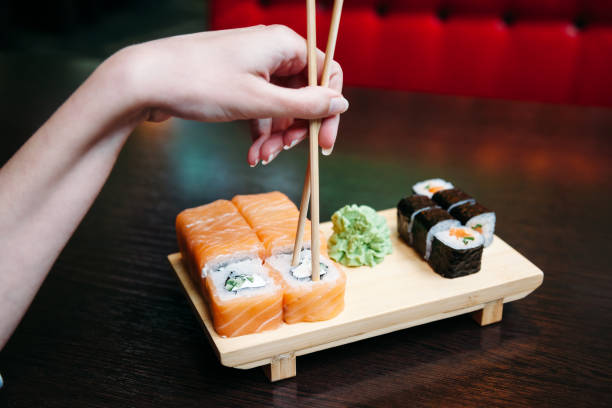 istock young woman wrong eating sushi with chopsticks 1139929175