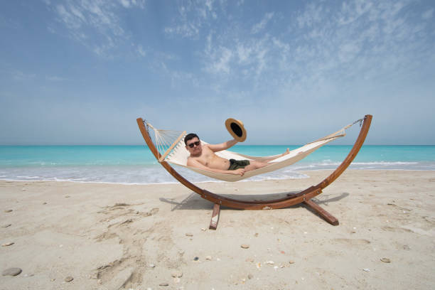 istock man lying on a hammock resting on the beach 1139930669