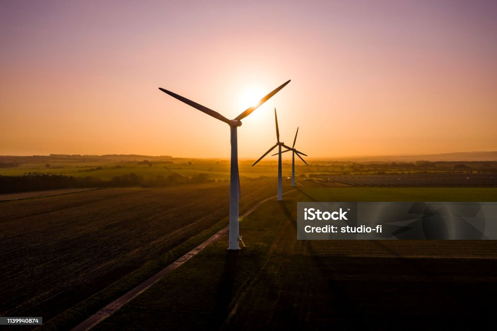 Three wind turbines Three large wind turbines at sunrise taken from the air Wind Turbine Stock Photo