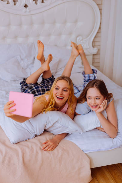 istock Sisters smiling while making photo on tablet chilling in bed 1139941528