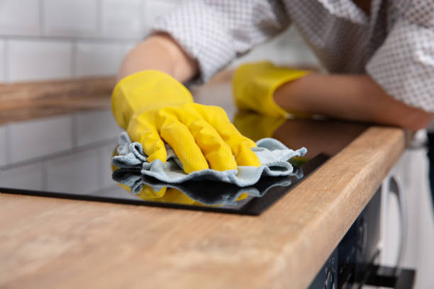istock Young woman hands cleaning a modern black induction hob by a rag, housework 1139943438