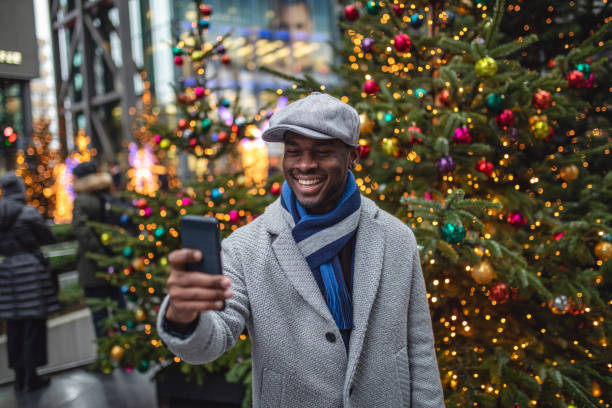 homem novo considerável que toma um selfie - christmas tree standing clothing adventure - fotografias e filmes do acervo