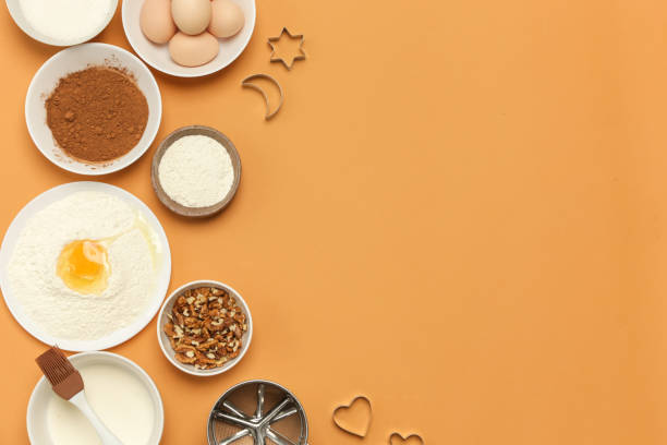 istock Creating a recipe, Top view of the basic baking ingredients on the orange table, cooking concept 1139946627