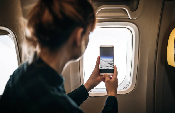istock Traveler Taking Pictures Using Phone From Airplane 1139947582