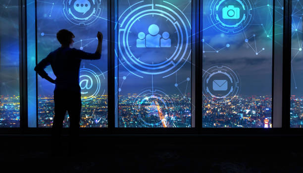 istock Social Media with man by large windows at night 1139948394