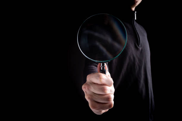 istock Man's hand, holding classic styled magnifying glass 1139948457