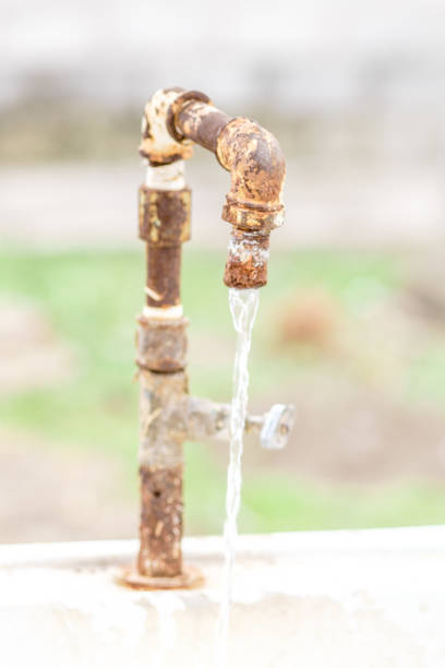 istock Old rusty water tap with flowing water in the garden. 1139950488