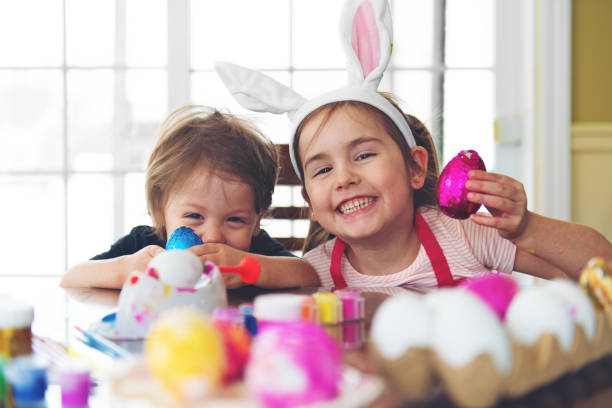 sorella e fratello che mangiano cioccolato - easter easter egg child chocolate foto e immagini stock