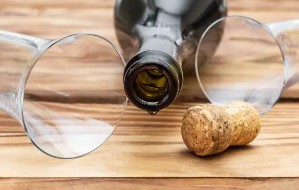 Photo of Bottle from champagne, cork and glasses on the table. Close up.