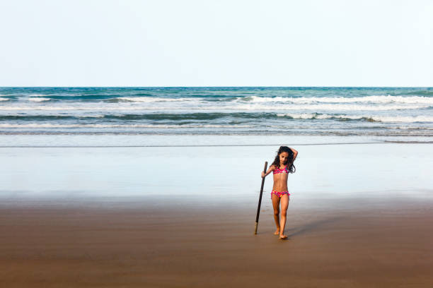 close up little girl playing on golden color sandy beach