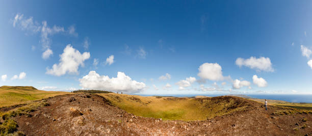 Adventurous woman approaching extinct volcano crater in Easter Island