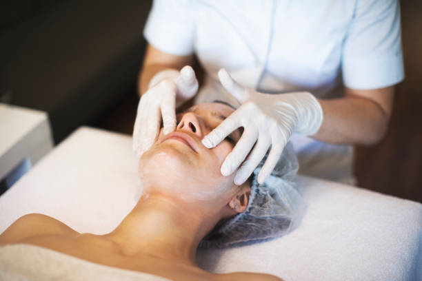 美容師自宅で仕事 - massaging beautician beauty treatment facial massage ストックフォトと画像