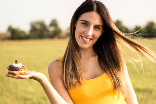 istock Happy woman holding donuts 1139958959